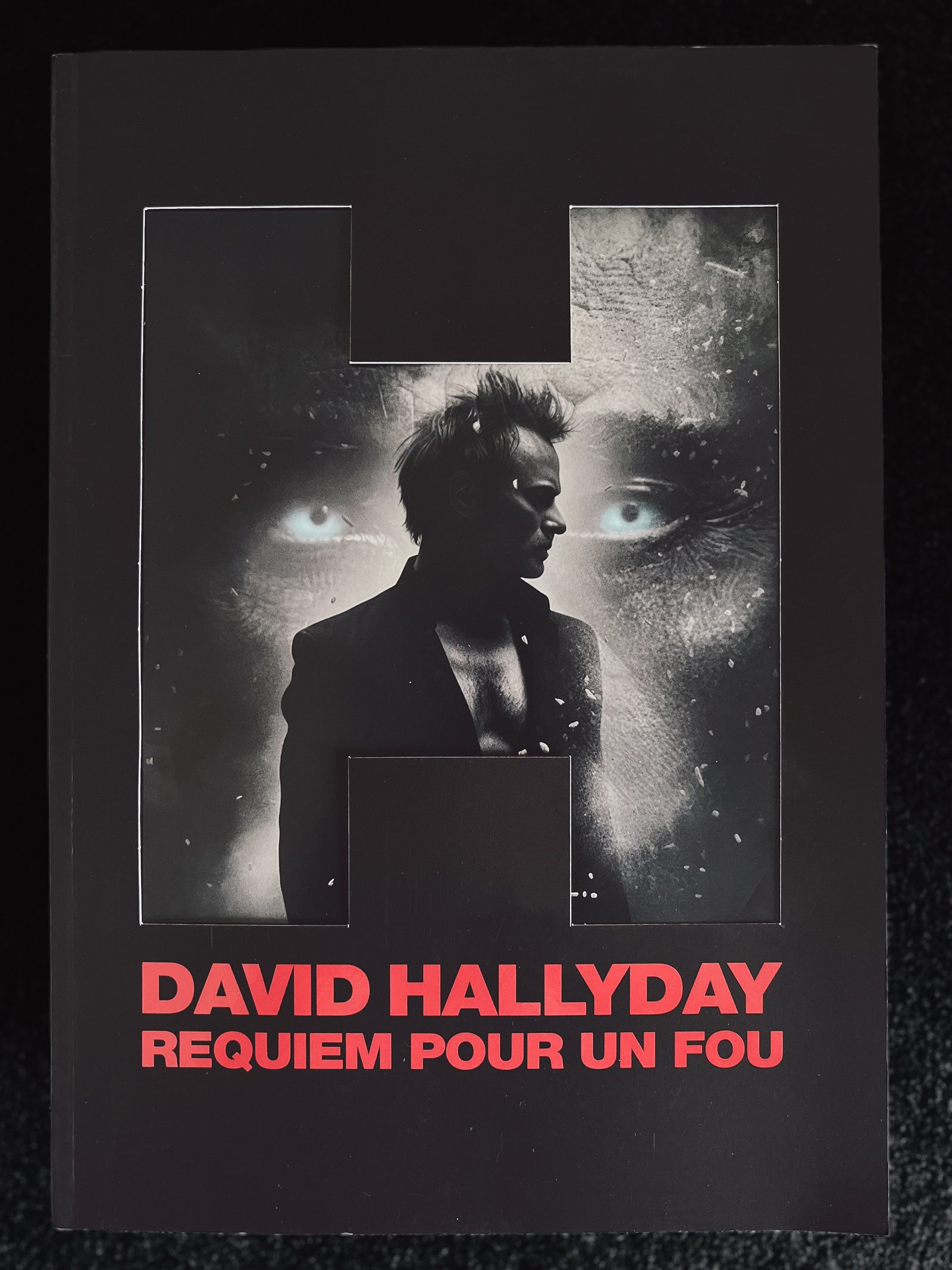 Couverture d'un livre intitulé "Requiem pour un fou" de David Hallyday, avec un portrait en noir et blanc de l'auteur en profil, superposé à une photo en gros plan d'un visage féminin avec des yeux bleus brillants.